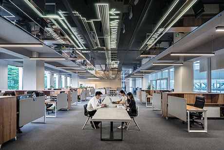People sitting at a long desk in open space office