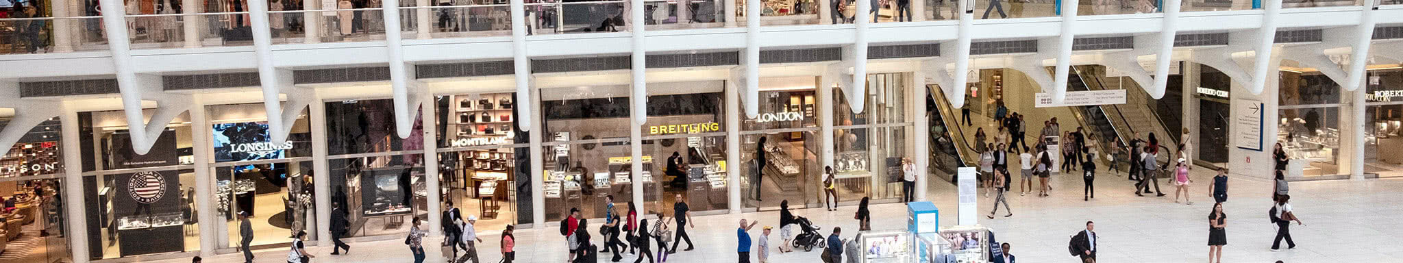 A commercial space with shopfronts and people viewed from above