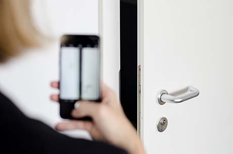 A person taking a picture of a door lock