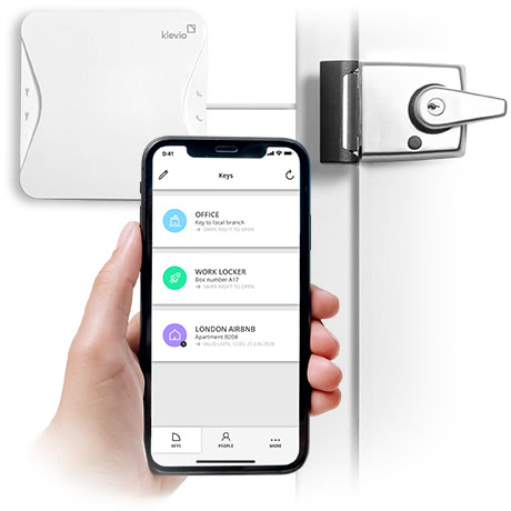 A hand holding a smartphone with a smart lock app showing digital keys in the foreground, with a smart lock device connected to a door lock in the background