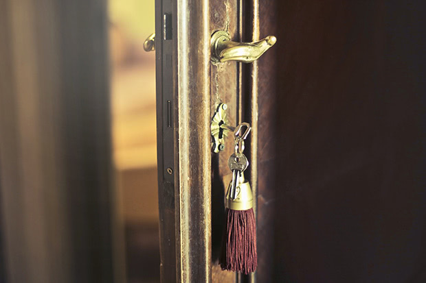 A traditional lock on a wooden door with a key inserted